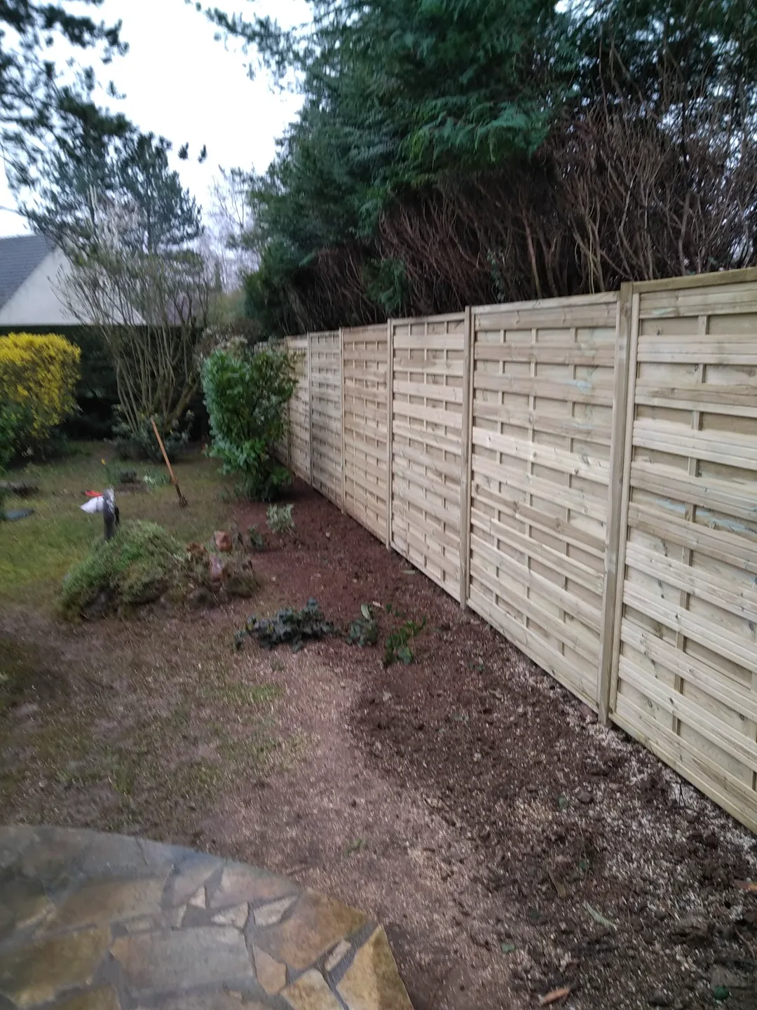 Clôture bois neuve posée le long d'un jardin